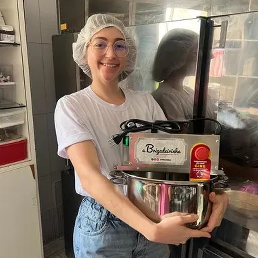 Bianca segurando a panela mexedora usada na loja